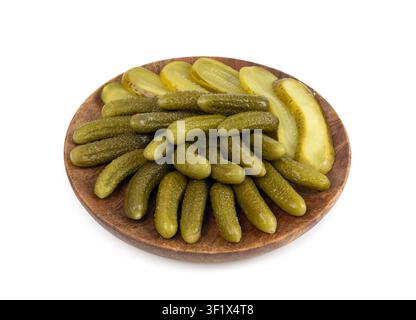 Pickled sliced cucumbers on wood plate isolated. fermented food, marinated canned vegetables, gherkins, pickled cucumbers on white background Stock Photo