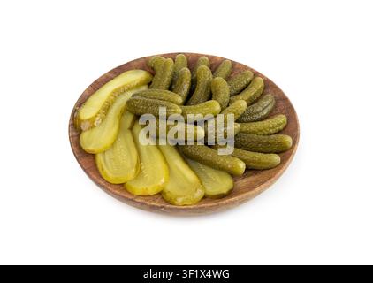 Pickled sliced cucumbers on wood plate isolated. fermented food, marinated canned vegetables, gherkins, pickled cucumbers on white background Stock Photo