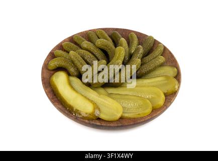 Pickled sliced cucumbers on wood plate isolated. fermented food, marinated canned vegetables, gherkins, pickled cucumbers on white background Stock Photo