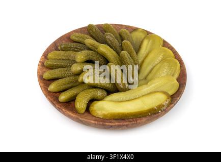 Pickled sliced cucumbers on wood plate isolated. fermented food, marinated canned vegetables, gherkins, pickled cucumbers on white background Stock Photo