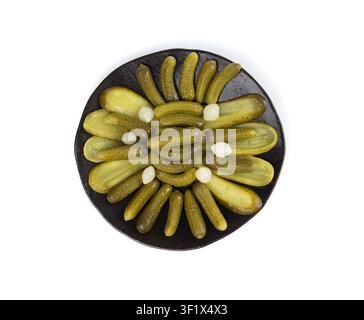 Pickled sliced cucumbers on black plate isolated. fermented food, marinated canned vegetables, gherkins, pickled cucumbers on white background Stock Photo