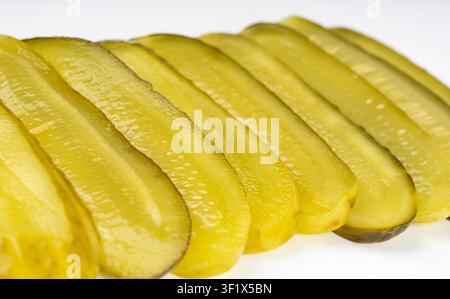 Pickled sliced cucumbers isolated, thinly sliced fermented food, marinated canned vegetables, gherkins, pickled cucumbers on white background Stock Photo