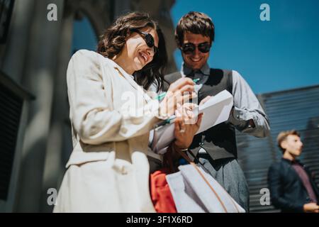 Business colleagues collaborating outdoors, smiling while signing documents and reviewing paperwork together Stock Photo