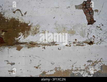 Horizontal close up of a weathered white painted wall surface with paint cracked and flaking Stock Photo