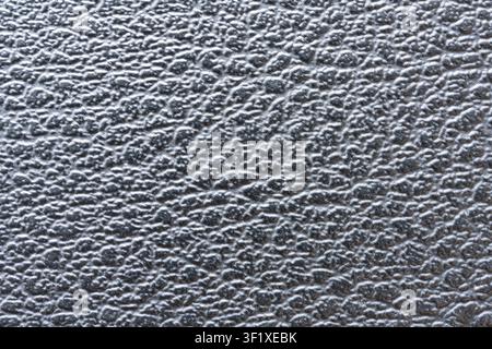 A detailed close-up shot displays the textured surface of grey leather. The image emphasizes the intricate grain and subtle variations in the material Stock Photo