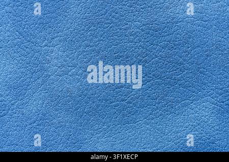 A detailed close-up shot displays the textured surface of blue leather. The image emphasizes the intricate grain and subtle variations in the material Stock Photo