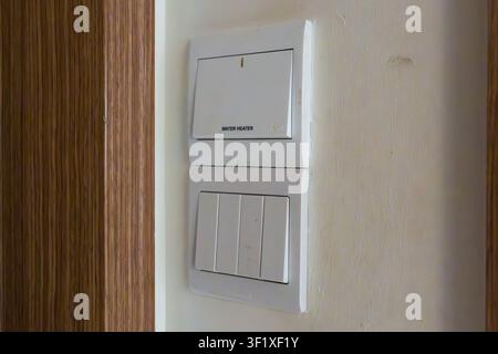 White wall-mounted light switch panel installed vertically. Modern design with two distinct toggle controls. Simple clean lines for easy use and insta Stock Photo