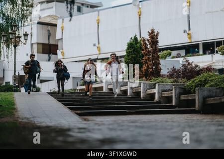 High school students running and walking together down outdoor steps near a campus building Stock Photo