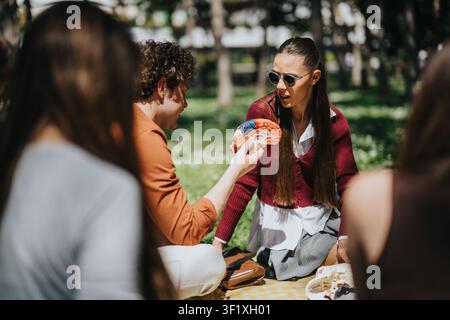 High school students discussing brain model during outdoor group lesson in a sunny park Stock Photo