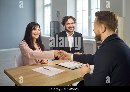 Successful job interview handshake as recruiters welcome hired candidate in office Stock Photo