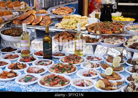 Ballaro Market Palermo street food stall with wine and assorted sicilian street food. Stock Photo