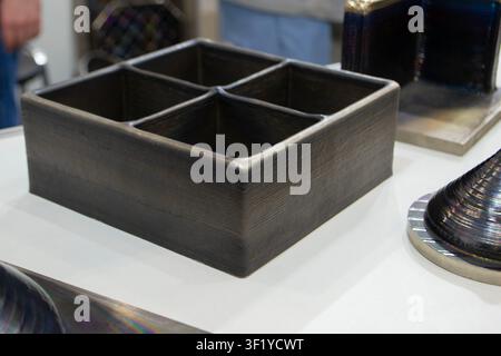Metal four-compartment organizer container manufactured using industrial 3D metal printing. Additive manufacturing. Model printed on 3D printer. Metal alloy. Object printed on 3D printer from metal. Stock Photo