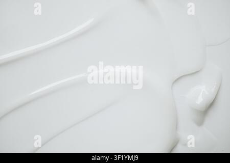 White cosmetic lotion texture creating abstract waves and soft peaks on clean background Stock Photo