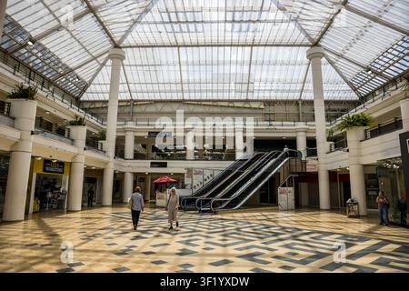 Interior view of the multi-level escalators, tiled floors, and structural pillars inside the Whitgift Centre shopping mall in Croydon, London Stock Photo