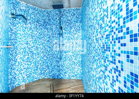 Modern bathroom shower with blue mosaic tiles and wooden floor Stock Photo