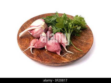 Young Garlic Cloves on Wood Plate Isolated, Garlic Clove Group, Seasoning Bulb, Natural Spices Food Ingredient with Green Parsley and Dill on White Ba Stock Photo
