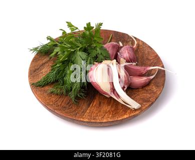 Young Garlic Cloves on Wood Plate Isolated, Garlic Clove Group, Seasoning Bulb, Natural Spices Food Ingredient with Green Parsley and Dill on White Ba Stock Photo