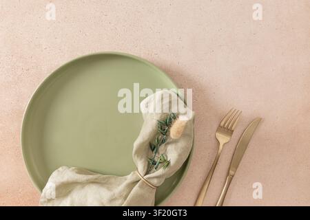 Close up of elegant green ceramic plate with linen napkin and golden cutlery. Stylish autumn dining table inspiration with natural decor. Stock Photo