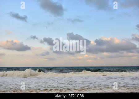 Ultra-high-resolution close-up of powerful ocean waves crashing against rugged dark volcanic rocks. Foamy white spray erupts mid-impact. Stock Photo