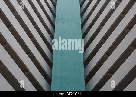 Vertical teal panel contrasts with diagonal concrete stripes. Abstract pattern suggests modern architectural design. Angles create strong visual symme Stock Photo