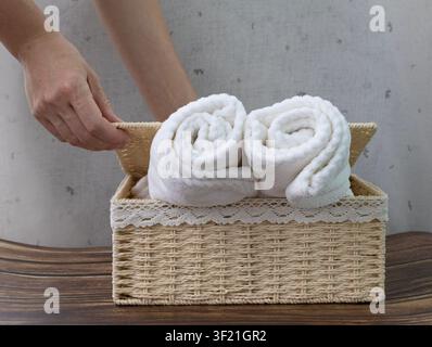 Opening Wicker Storage Basket with Rolled White Towels at Home Stock Photo