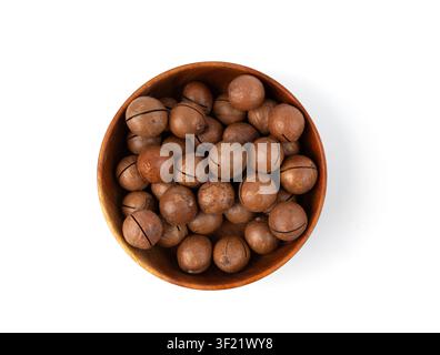 Macadamia nuts in bowl isolated. Natural raw peeled macadamia seeds and shells, the hardest and most expensive nuts in the world on white background t Stock Photo