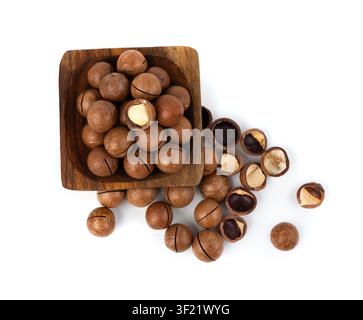 Macadamia nuts in bowl isolated. Natural raw peeled macadamia seeds and shells, the hardest and most expensive nuts in the world on white background t Stock Photo