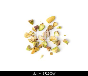 Fried salt pistachio nuts pieces pile isolated. Baked broken pistachios grains, crumbled roasted green pistache fruits and chopped kernels on white ba Stock Photo