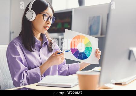 Female Asian Design Student Presenting Color Wheel At Home Office, Creative Concept Stock Photo
