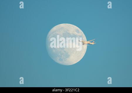 Japan Airlines Airbus A350-900 (JA01XJ) passing in front of the moon during departure in the evening sky Stock Photo