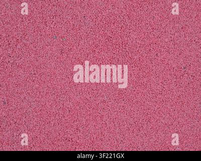 seamless rubber surface of a rich pink-red color. The surface consists of finely pressed crumbs and has a porous, rough texture. Stock Photo