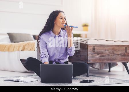 Focused Young Hispanic Woman Working On Laptop And Using Smartphone At Home, Business Concept Stock Photo