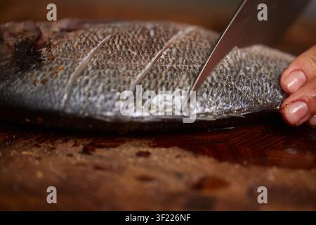 Chef preparing raw sea bream for cooking Stock Photo