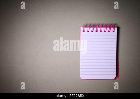 Close-up of a small spiral notebook open on a desk. Writing for taking notes and not forgetting anything at school. Stock Photo
