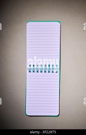Close-up of a small spiral notebook open on a desk. Writing for taking notes and not forgetting anything at school. Stock Photo