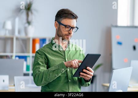 Man Using Tablet In Office, Focused On Work, Professional Concept Stock Photo