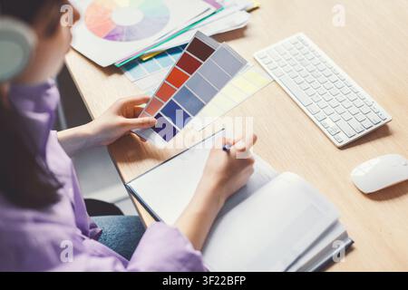 Female Designer Analyzing Color Palette While Working In Modern Office, Creative Concept Stock Photo