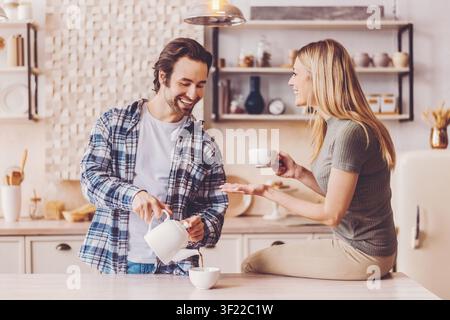 Enjoying Coffee Together in a Cozy Kitchen During Morning Stock Photo