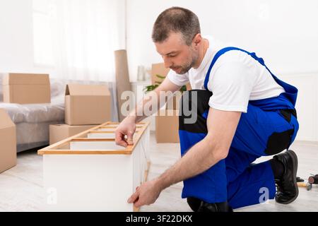 Professional Carpenter Man Repairing Shelf Assembling Furniture Indoors Stock Photo