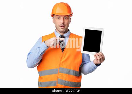 Surprised Worker Man Showing Tablet Screen On White Studio Background Stock Photo
