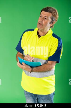 Employee in special reflective clothing on a green background Stock Photo