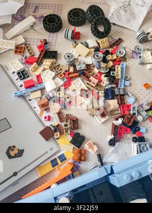 Vilnius, Lithuania - 2026-07-06 - Scattered LEGO bricks, wheels and assembly instruction manual during the building process Stock Photo