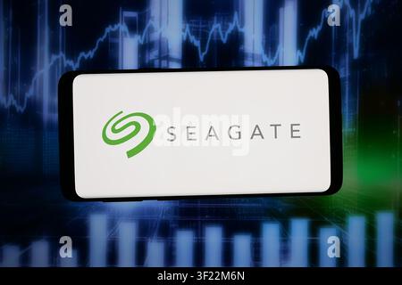 In this photo illustration, the logo of company Seagate Technology Holdings plc is displayed on a smartphone in front of abstract background on computer screen. Stock Photo