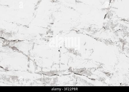Horizontal close-up view of a natural white marble stone texture showing detailed grey veins and rough cracks on a polished mineral surface for luxury Stock Photo