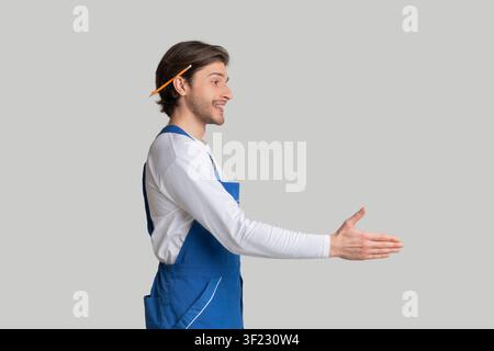 Young Architect In Work Uniform Giving Hand For Handshake, Side View Stock Photo