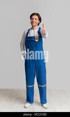 Professional House Painter In Work Uniform Gesturing Thumb Up Stock Photo