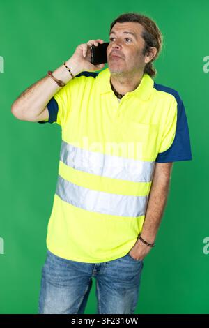 Male person wearing in reflective polo is talking on phone Stock Photo