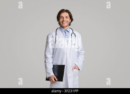Portrait of positive young therapist with medical chart in hands Stock Photo