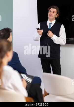 Male business trainer explaining topic to professionals using digital board Stock Photo
