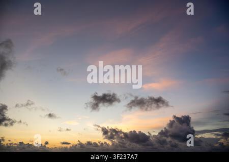 Soft pastel sky with scattered clouds during sunset. Calm atmosphere, natural background, and peaceful evening sky concept. Stock Photo